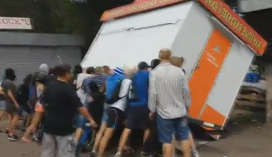 В Киеве люди в “балаклавах” перевернули киоск с выпечкой (видео)