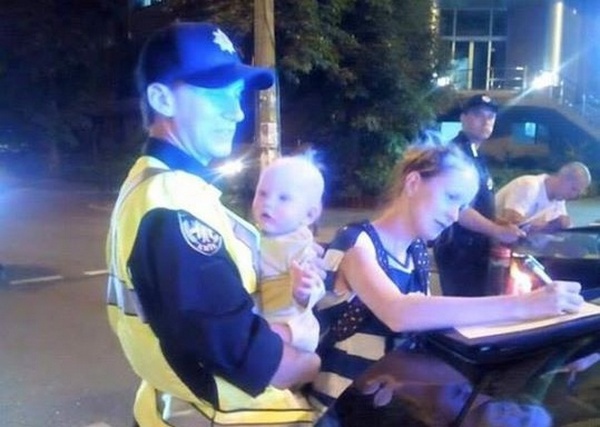Полицейский профессионально понянчил ребенка мамы-нарушительницы (фото)