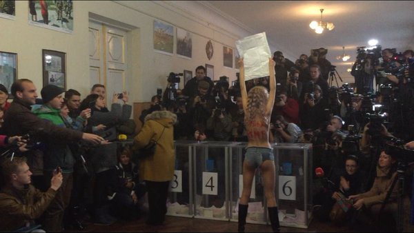 Частично оголенная активистка Femen протестовала на избирательном участке во время голосования Кличко (фото, видео)