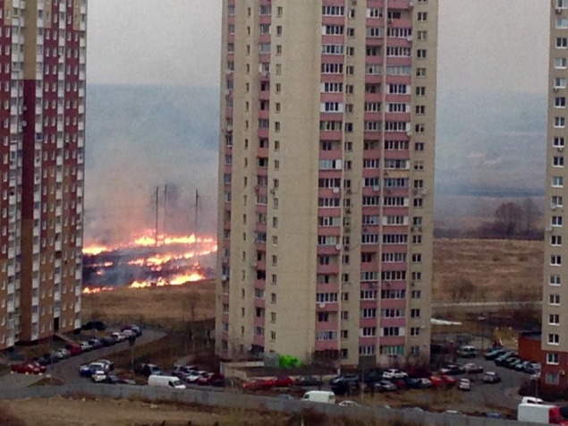 В Киеве на Троещине возле жилых домов горит трава