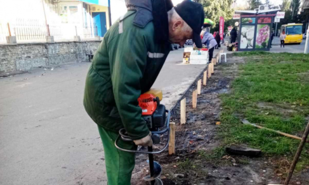 На столичных Березняках коммунальщики пытаются оградить зеленые зоны от автомобилей деревянными столбиками