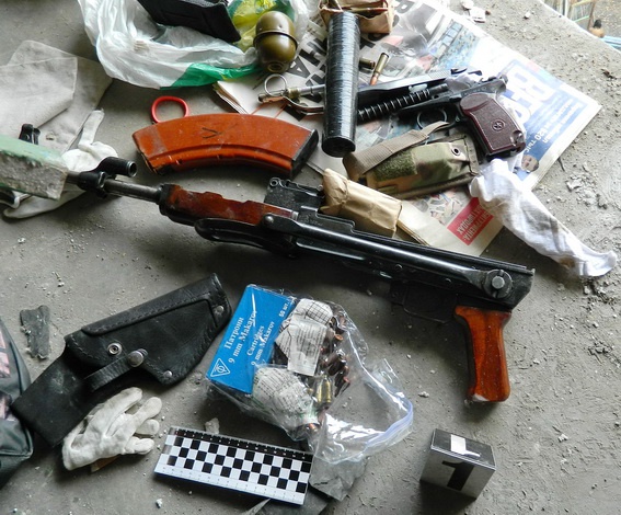 В подъезде многоэтажки в Киеве ремонтники “откопали” тайник с оружием (фото, видео)
